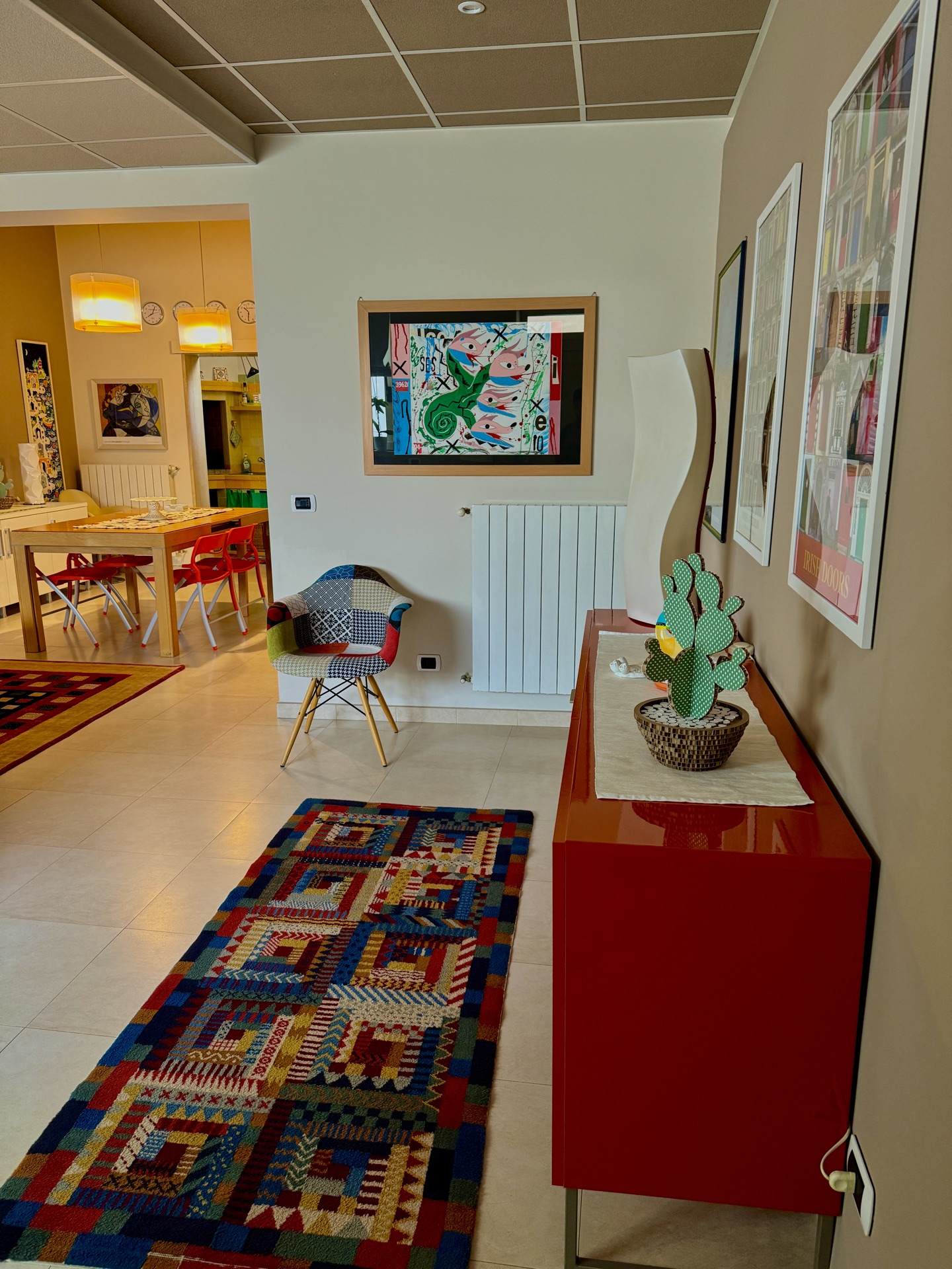 Ingresso con madia rossa e quadri